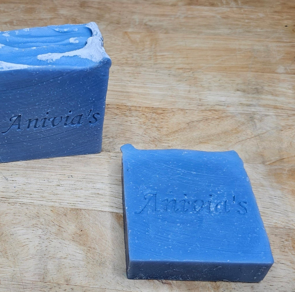 Two blue bars of soap with 'Anivia's' branding on a wooden surface.